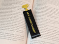 Black rectangle bookmark with yellow text reading "NEW ACHIEVEMENT!" with a yellow trophy icon on one end