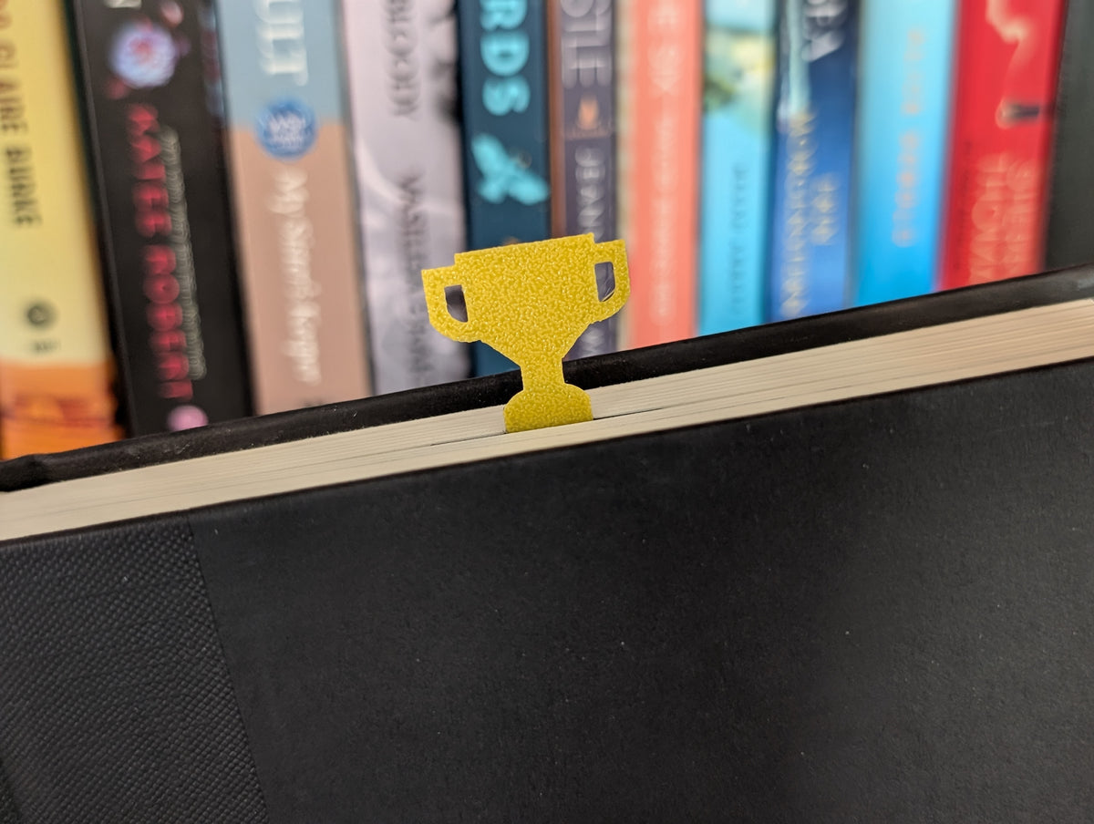 Yellow trophy sticking out of the top of a book