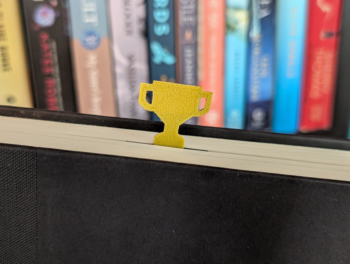Yellow trophy sticking out of the top of a book